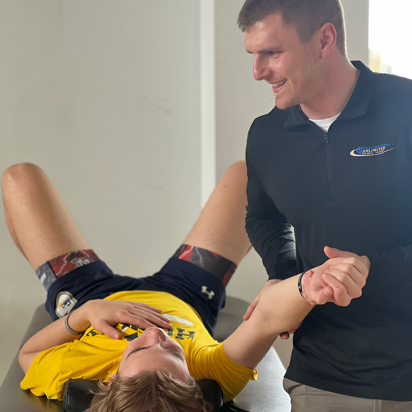 bill helping patient with shoulder mobility